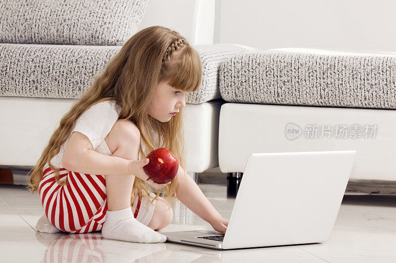玩笔记本电脑的小女孩。
