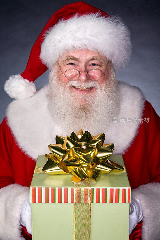 真正的圣诞老人拿着礼物的照片