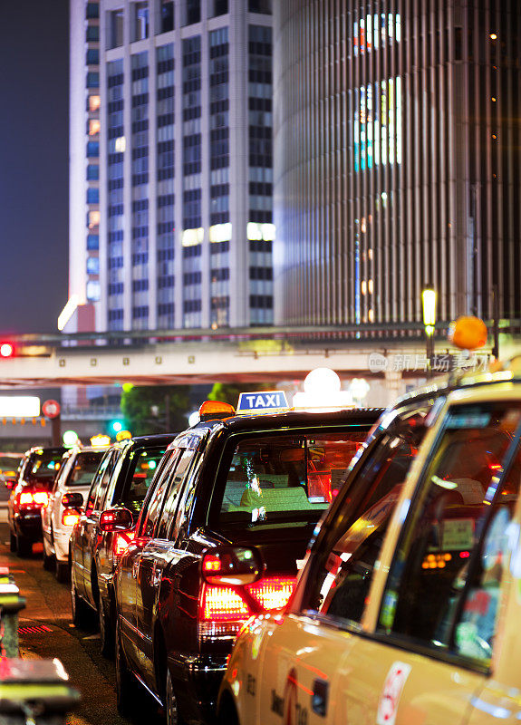 晚上，东京拥挤的街道上停着长长的出租车。