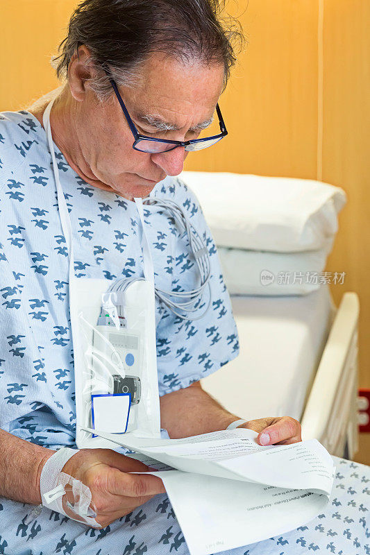 老人坐在病床上阅读信息