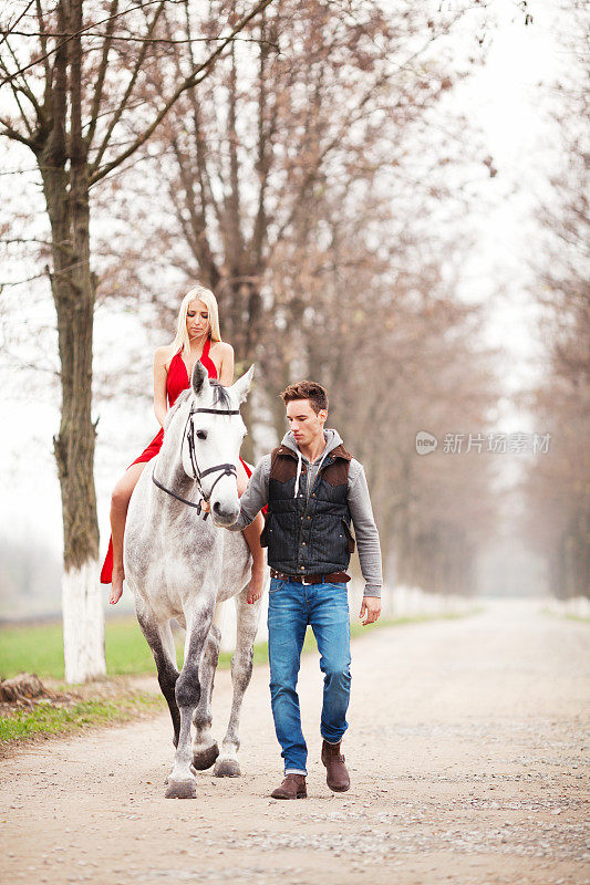 漂亮的女孩和英俊的男人骑着白马