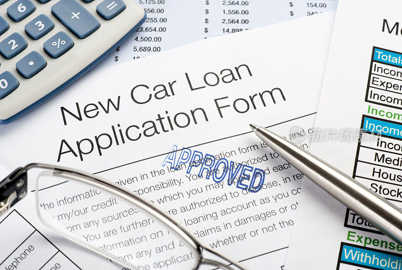 批准的汽车贷款申请表连同钢笔、计算器