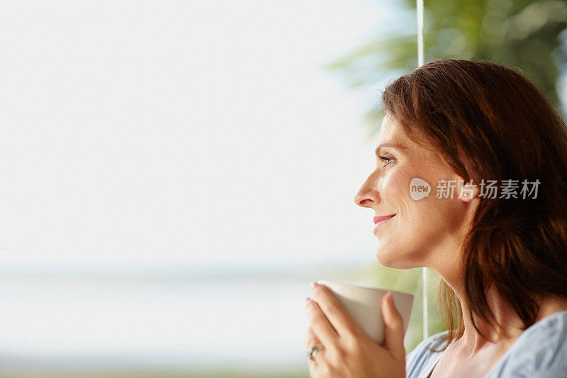 拿着咖啡杯的漂亮女人看着复印空间