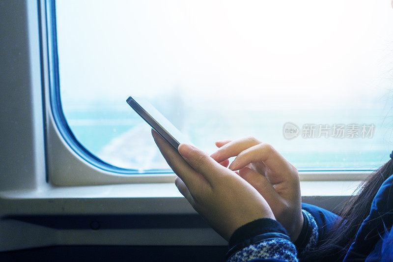 一名女子在火车上使用智能手机