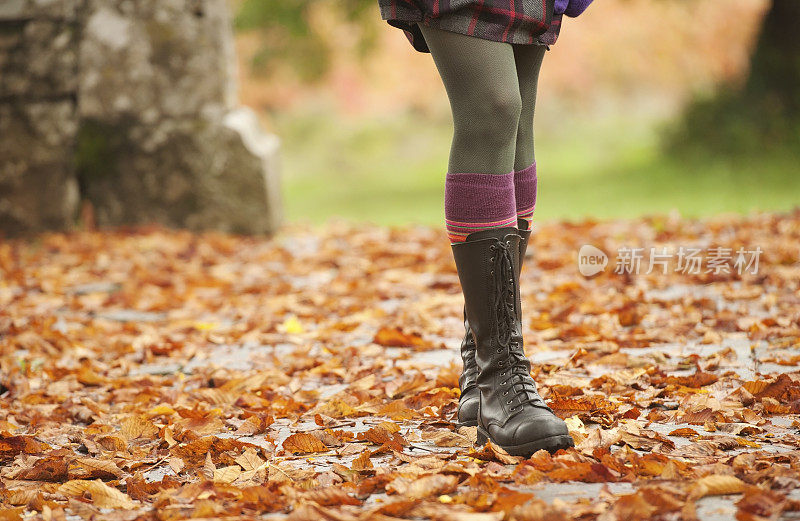 女人的腿在秋天行走