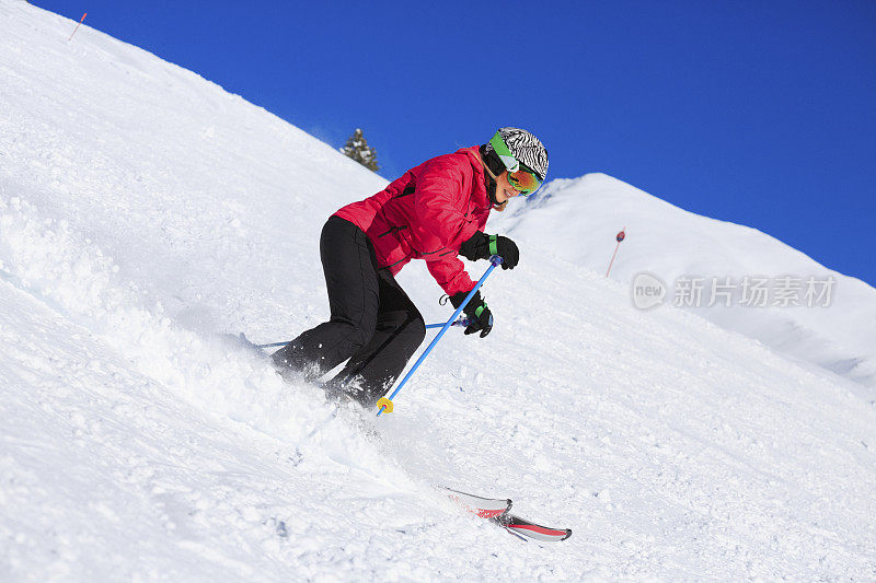 在阳光明媚的滑雪胜地滑雪的中年妇女滑雪