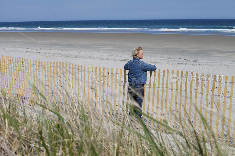 一个女人在海滩上望着大海。