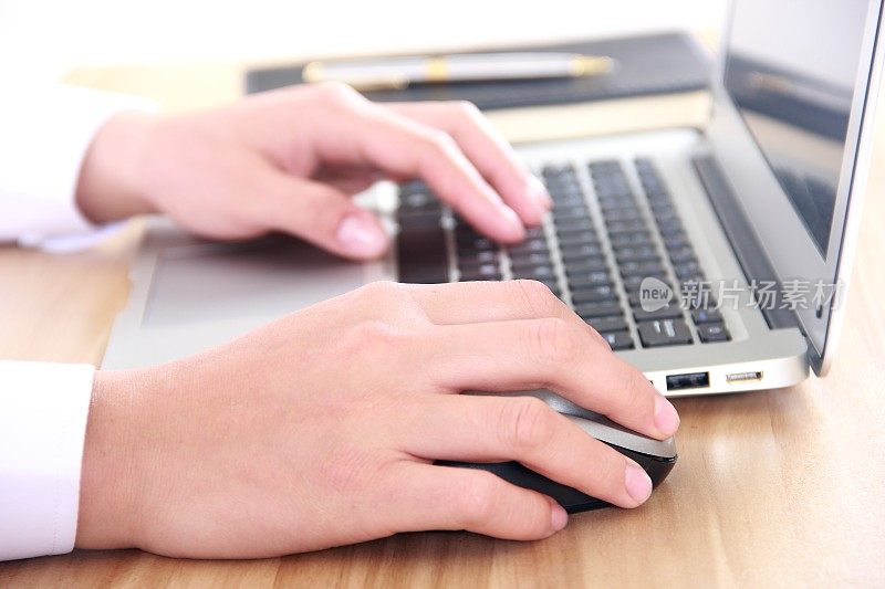 女性用手在笔记本电脑上打字