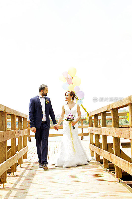 快乐的新婚夫妇和彩色气球