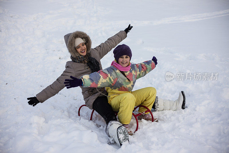 母亲和女儿喜欢坐雪橇