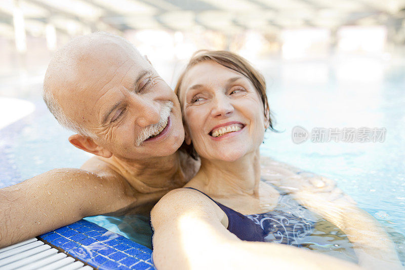 老年夫妇在酒店游泳池里放松