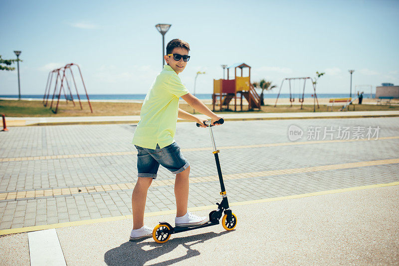 男孩骑着滑板车在公园里