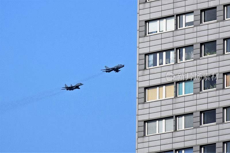 战斗机在城市的建筑物之间飞行