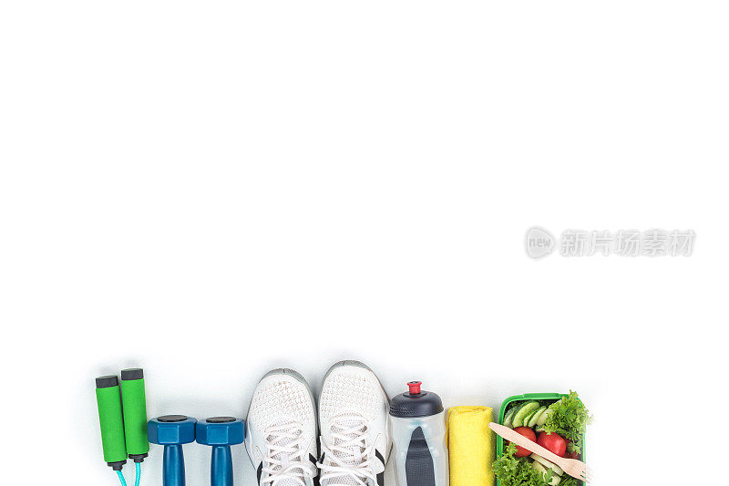 俯视图哑铃，跳绳，运动鞋，瓶装水和蔬菜沙拉孤立在白色