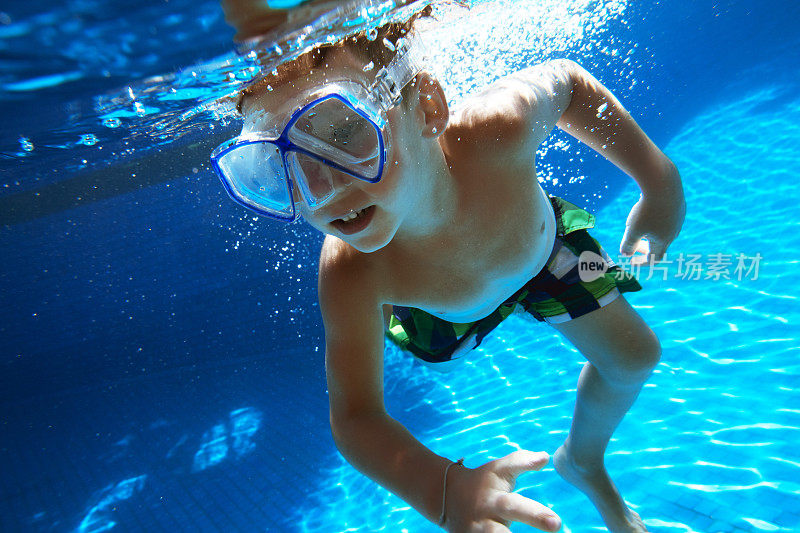 男孩戴着通气管面罩在水下游泳