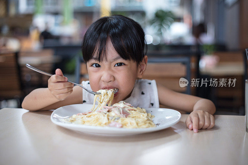 亚洲华人小女孩在吃意大利面