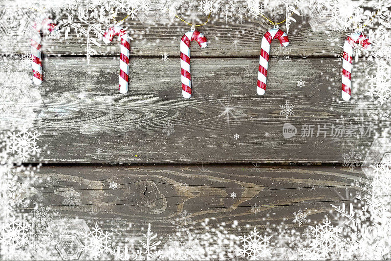 圣诞装饰，糖果手杖在木制的白雪覆盖的背景