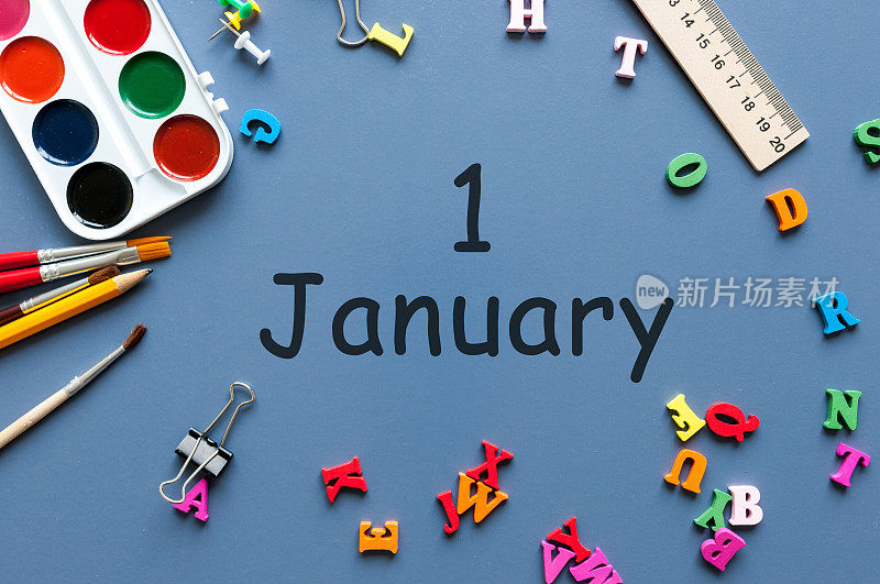 1月1日。一月的第一天，日历上的蓝色背景与学校用品。冬天