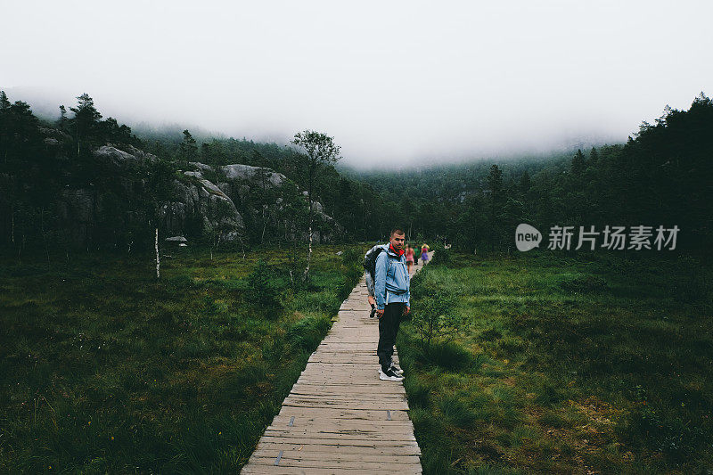 一名男子徒步穿越挪威的森林前往布道石