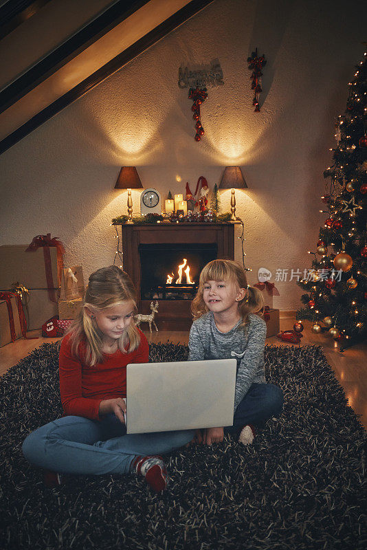 在舒适的圣诞气氛中，孩子们在客厅里拿着笔记本