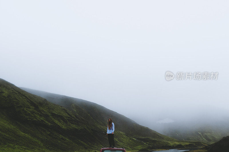 在冰岛多雾的高地上，一名女子坐在汽车上