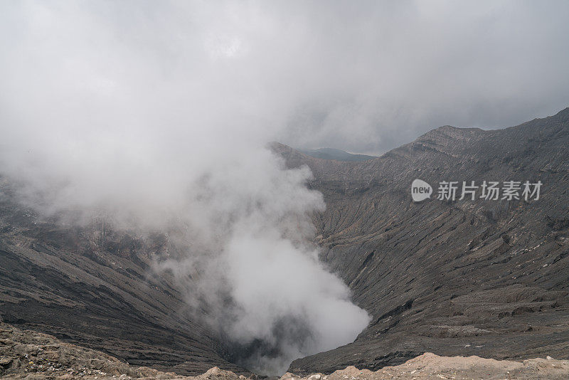 在印度尼西亚东爪哇岛的布罗莫山国家公园，布罗莫火山口边缘有蒸汽。旅游目的地冒险的自然概念