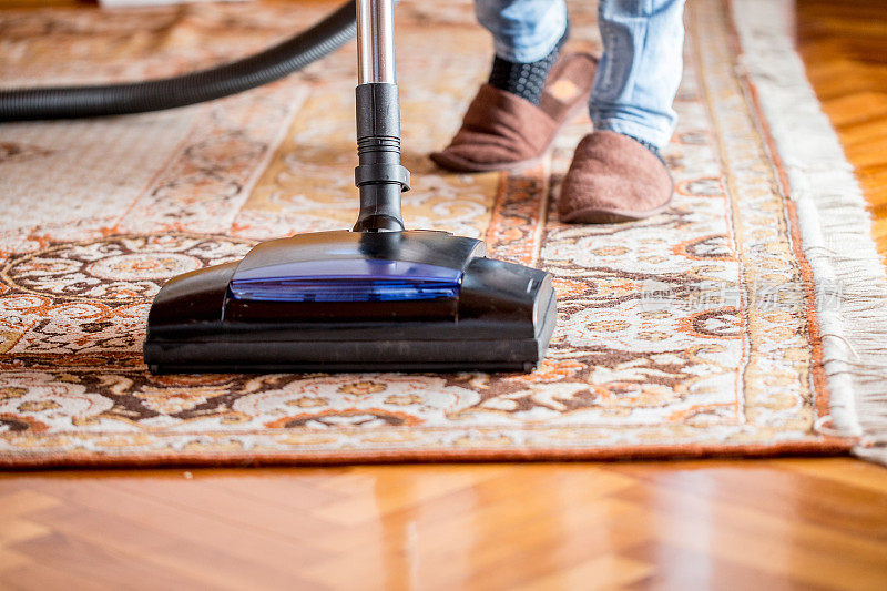 妇女用吸尘器清洁旧地毯