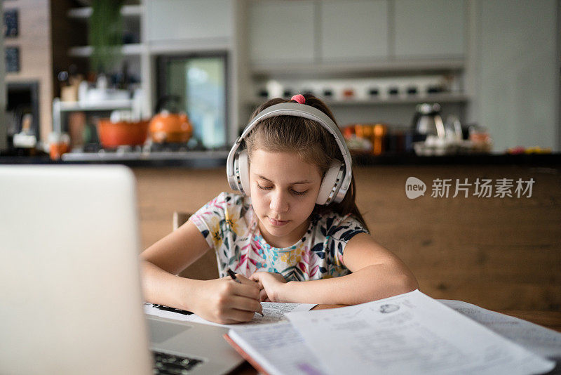 女孩在家里用笔记本学习