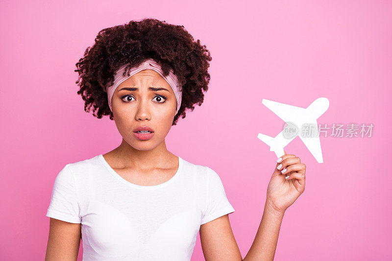 照片沮丧沮丧的女孩拿着纸飞机戴头巾白色t恤孤立粉红色的背景