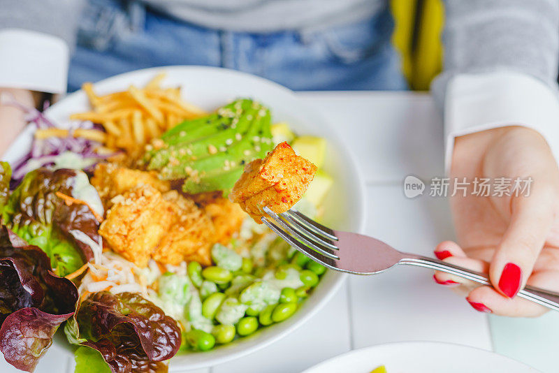 一个女人吃素食沙拉碗的特写