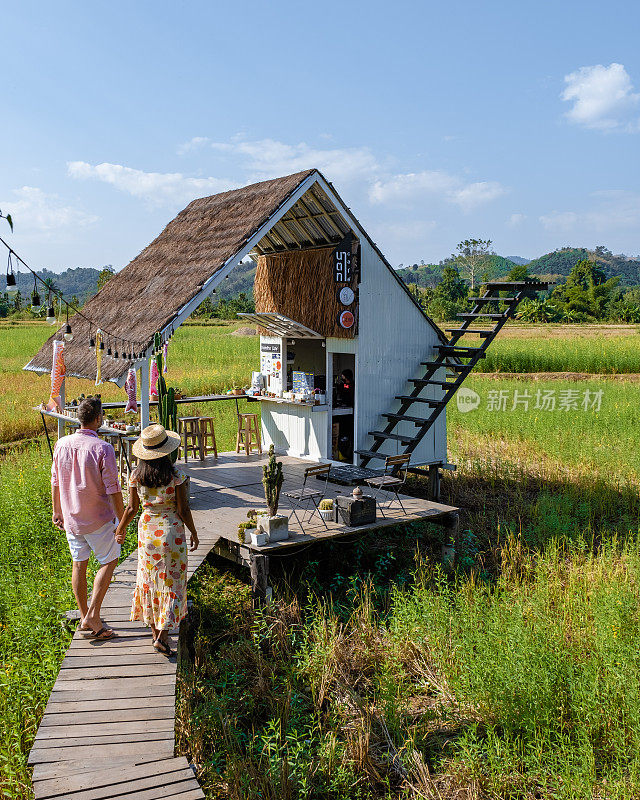 在泰国南部，人们在有白色楼梯的稻田里参观一家咖啡馆