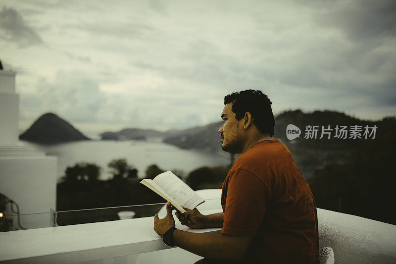 亚洲人在酒店阳台上看书