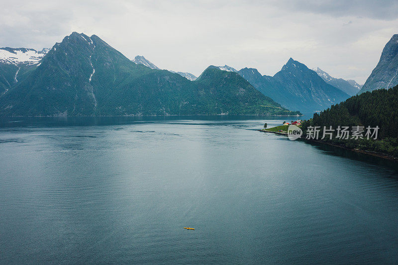 在挪威风景优美的峡湾上，一名女性旅行者划皮艇的鸟瞰图