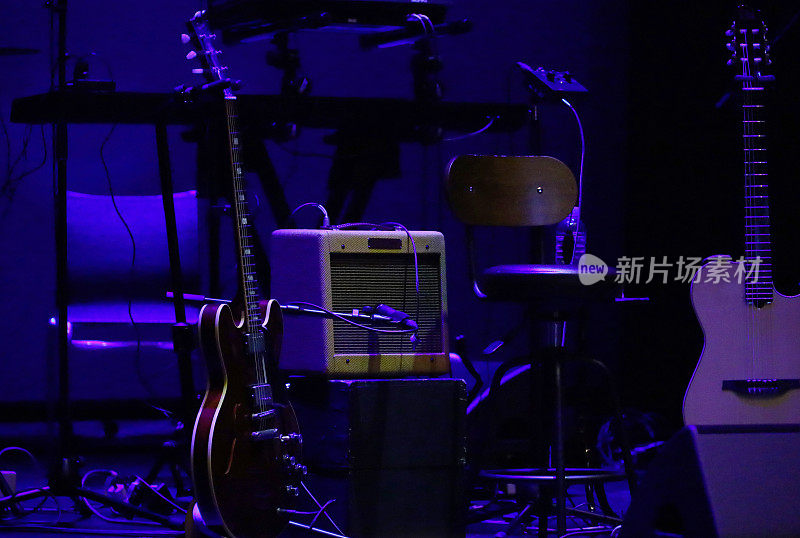 在演出前，一把吉他被放在灯光昏暗的舞台上
