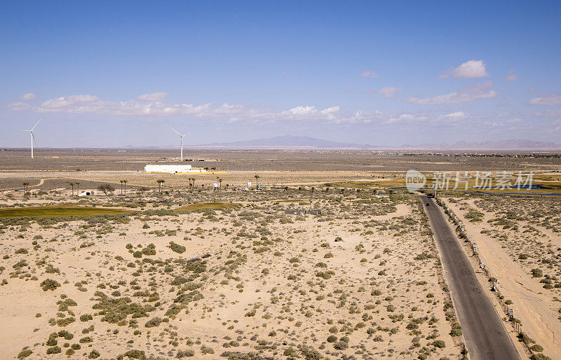 提高了沙漠道路和远处风力涡轮机的风景