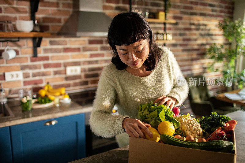 年轻的日本妇女在厨房里准备水果和蔬菜