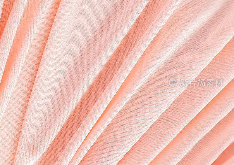 优雅的桃色纺织背景与柔软的褶皱。喜庆的背景颜色是2024年的桃色绒毛。一个拷贝空间。