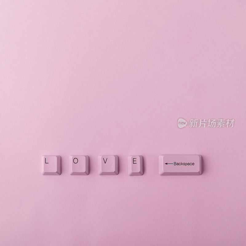 字爱的顶视图由键盘键孤立在粉红色的背景。复杂的关系，争吵，初恋。