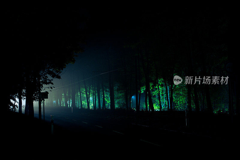 夜间行驶在乡村道路上的汽车的前灯