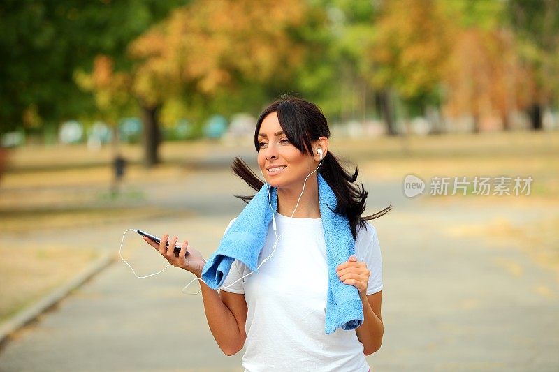 年轻的健身女性慢跑和听音乐