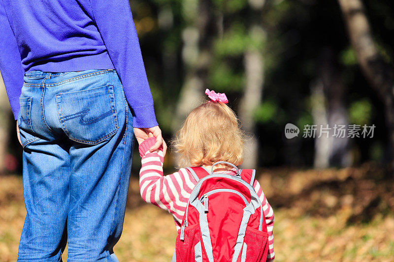 父亲背着背包送小女儿去学校或日托所