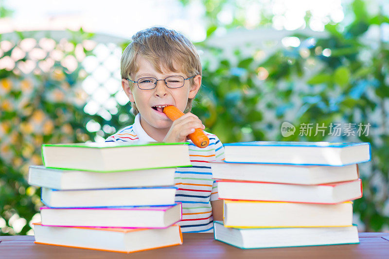 戴着眼镜和书的快乐小男孩