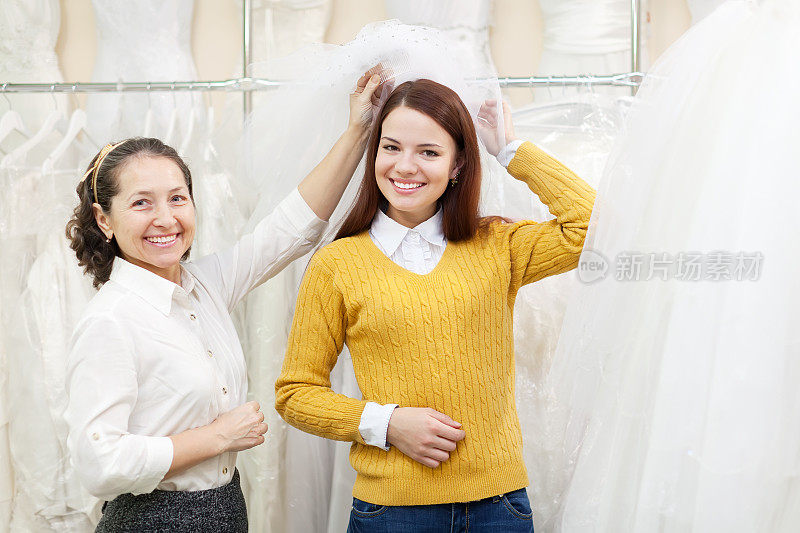 店员帮助新娘挑选婚纱
