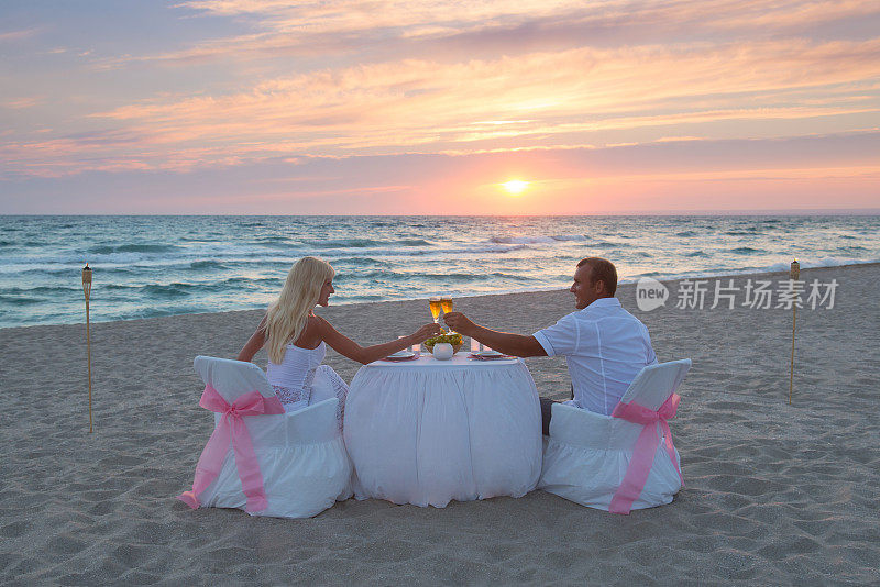 一对情侣在海滩上吃烛光浪漫晚餐