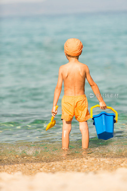 小男孩站在海滩上