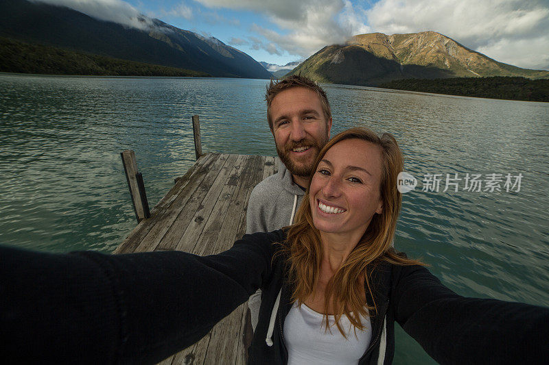 年轻夫妇站在湖边码头的自画像