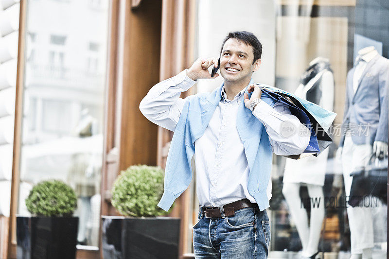 都市生活系列:拿着购物袋打电话的男人