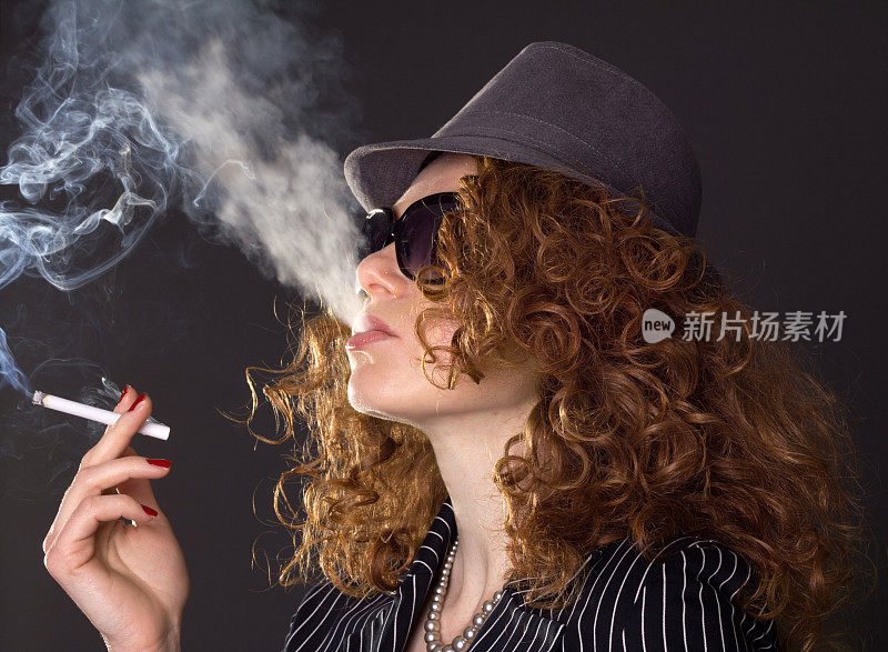 有魅力的女人戴着一顶带有香烟的帽子。