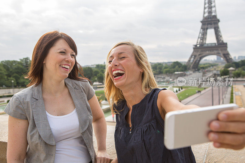 巴黎的两个女孩用手机自拍――埃菲尔铁塔