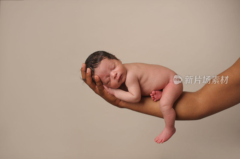 非裔美国婴儿在爸爸有力的手中平静地睡觉